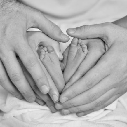 parents hands and baby feet
